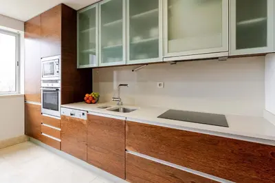 a kitchen with wooden cabinets and a sink at Modern & Spacious Flat with Garage by HostWise in Vila Nova de Gaia