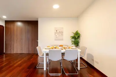 a dining room with a white table and chairs at Modern & Spacious Flat with Garage by HostWise in Vila Nova de Gaia
