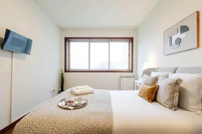 a white bedroom with a bed with a tray on it at Modern & Spacious Flat with Garage by HostWise in Vila Nova de Gaia