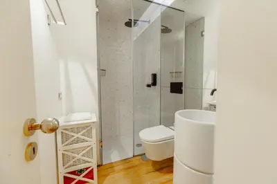 a white bathroom with a toilet and a shower at Historical Taipas Apartments by Vacationy in Porto