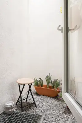 a stool and potted plants sitting next to a door at GuestReady - Enjoy Comfort in Porto in Porto