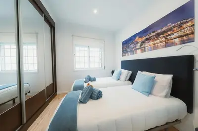 a bedroom with two beds and a painting on the wall at Douro Garden Home Rooftop in Vila Nova de Gaia