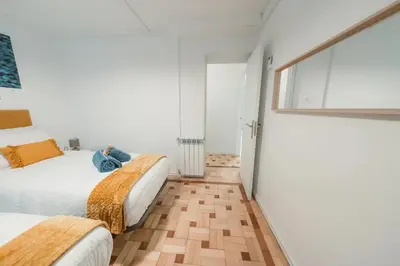 two beds in a room with white walls and wooden floors at Douro Garden Home Rooftop in Vila Nova de Gaia