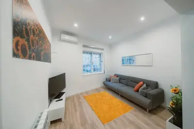 a living room with a couch and a television at Douro Garden Home Rooftop in Vila Nova de Gaia