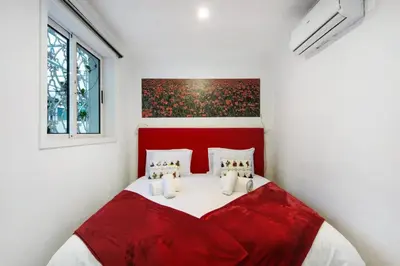 a red bed in a white room with a red headboard at Douro Garden House and Pool in Vila Nova de Gaia