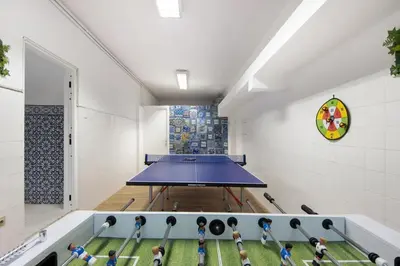 a gym with a ping pong table in a room at Douro Garden House and Pool in Vila Nova de Gaia