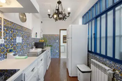a kitchen with a white refrigerator and blue tiles at Douro Garden House and Pool in Vila Nova de Gaia