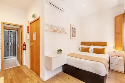 a small bedroom with a bed and a bathroom at D&S - Porto São Bento Apartments in Porto