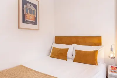 a bedroom with a bed and a picture of a train at D&S - Porto São Bento Apartments in Porto