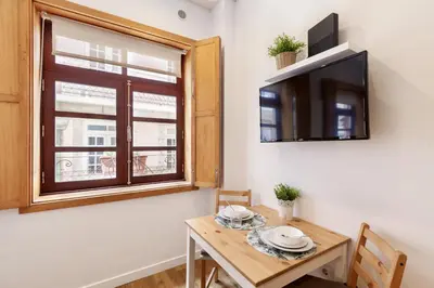 a small dining room with a table and a tv at D&S - Porto São Bento Apartments in Porto