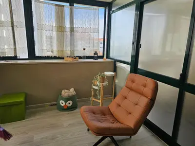 an orange chair in a room with a window at Fabulous Antero De Quental in Porto