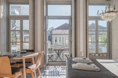 a bedroom with a bed and a table with chairs at Liiiving in Porto - Design Palace Studio in Porto