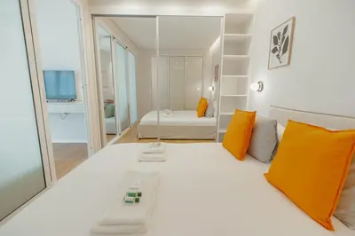 a bedroom with a large white bed with orange pillows at Bright Window Apartment by Vacationy in Porto