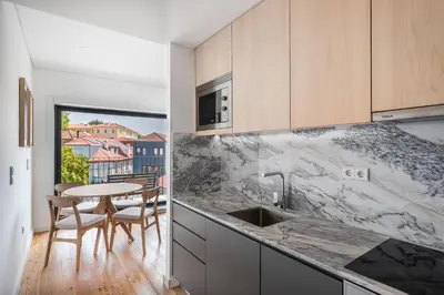 a kitchen with marble counter tops and a table at Spacious Studio Apartment in Porto