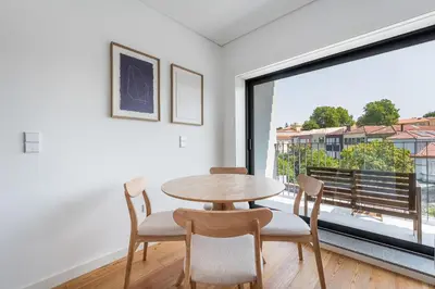 a dining room with a table and chairs and a large window at Spacious Studio Apartment in Porto