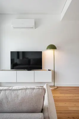 a living room with a couch and a flat screen tv at Spacious Studio Apartment in Porto