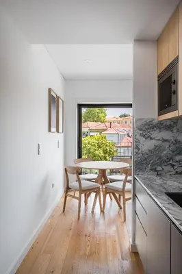 a kitchen with a table and chairs and a window at Spacious Studio Apartment in Porto