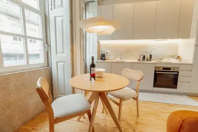 a kitchen with a table and two chairs and a bottle of wine at Deluxe Studio by Hosty in Porto