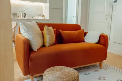 an orange couch with pillows on it in a living room at Deluxe Studio by Hosty in Porto