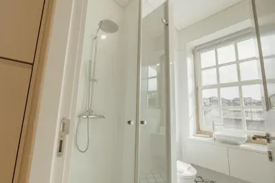 a white bathroom with a shower and a sink at Deluxe Studio by Hosty in Porto