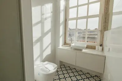 a white bathroom with a sink and a window at Deluxe Studio by Hosty in Porto