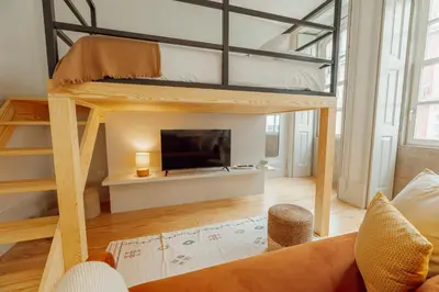 a loft bed in a living room with a tv at Deluxe Studio by Hosty in Porto