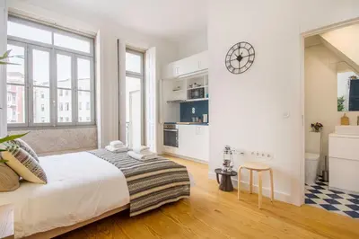 a bedroom with a bed and a clock on the wall at Porto Pacific - Almeida Garrett - estúdio a 5 minutos da Ribeira in Porto