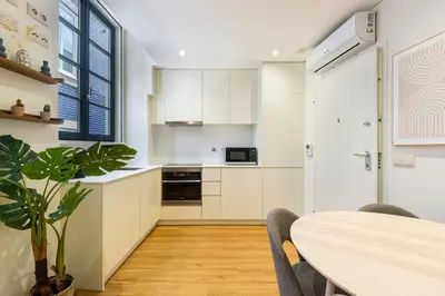 a kitchen with white cabinets and a table with chairs at GuestReady - Peaceful haven in Porto in Porto