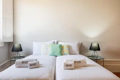 a white bed with two pillows on top of it at GuestReady - Cosme Heritage Apartments in Porto