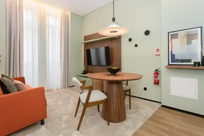 a living room with an orange couch and a tv at Bolhão Luxury Apartments in Porto
