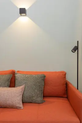 a couch with two pillows and a light above it at Bolhão Luxury Apartments in Porto