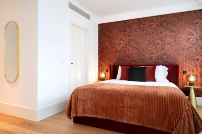 a bedroom with a bed with a red wall at Bonjardim Signature Apartment 4B in Porto