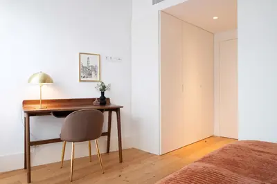 a bedroom with a desk and a chair next to a bed at Bonjardim Signature Apartment 4B in Porto