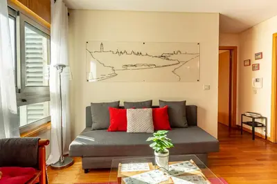 a living room with a couch and a drawing on the wall at Francos Relaxing Apartment by the metro in Porto