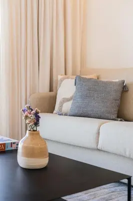 a living room with a couch and a vase with flowers at Aires Ornelas Gem, City Escape with Private Parking in Porto