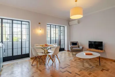 a living room with a table and chairs and a tv at Light-Filled Cedofeita Apt by HostWise in Porto