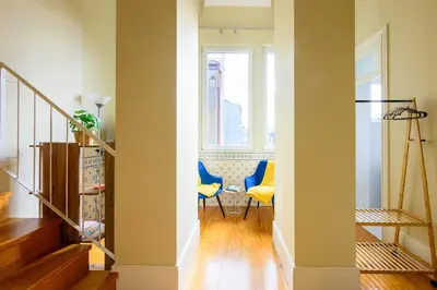 a hallway with two blue chairs and a window at Photography Apartments in Porto