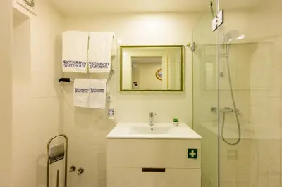 a white bathroom with a sink and a shower at Photography Apartments in Porto