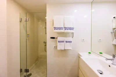 a bathroom with a shower and a sink with towels at Photography Apartments in Porto