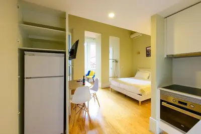 a small room with a bed and a bed and a room with a kitchen at Photography Apartments in Porto