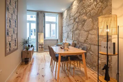 a dining room with a table and a stone wall at Luxury Style 10 with AC Downtown Porto near Metro in Porto