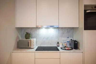 a kitchen counter with a microwave and a plate of food at Luxury Style 10 with AC Downtown Porto near Metro in Porto