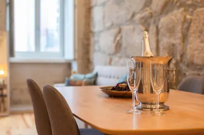 a bottle of champagne sitting on a table with glasses at Luxury Style 10 with AC Downtown Porto near Metro in Porto