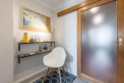 a white chair sitting next to a door in a room at GuestReady - Charming Cozy Getaway in Porto in Porto