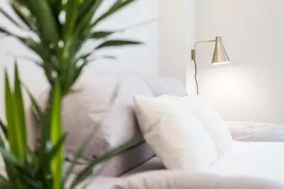 a white couch with pillows next to a lamp at GuestReady - Charming Cozy Getaway in Porto in Porto
