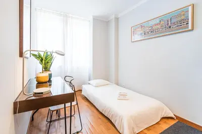 a white bedroom with a bed and a desk at GuestReady - Charming Cozy Getaway in Porto in Porto