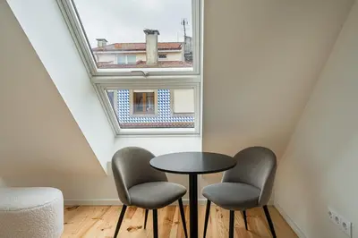 a table and two chairs in a room with a window at GuestReady - A fantastic home in Porto in Porto