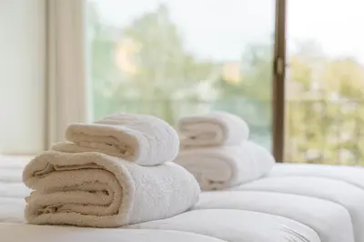a stack of towels sitting on a bed at GuestReady - DPV Residences in Porto
