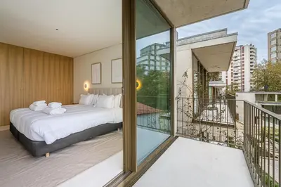 a bedroom with a large bed and a balcony at GuestReady - DPV Residences in Porto