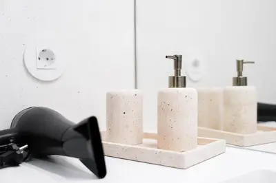 a bathroom with three soap dispensers on a counter at GuestReady - DPV Residences in Porto
